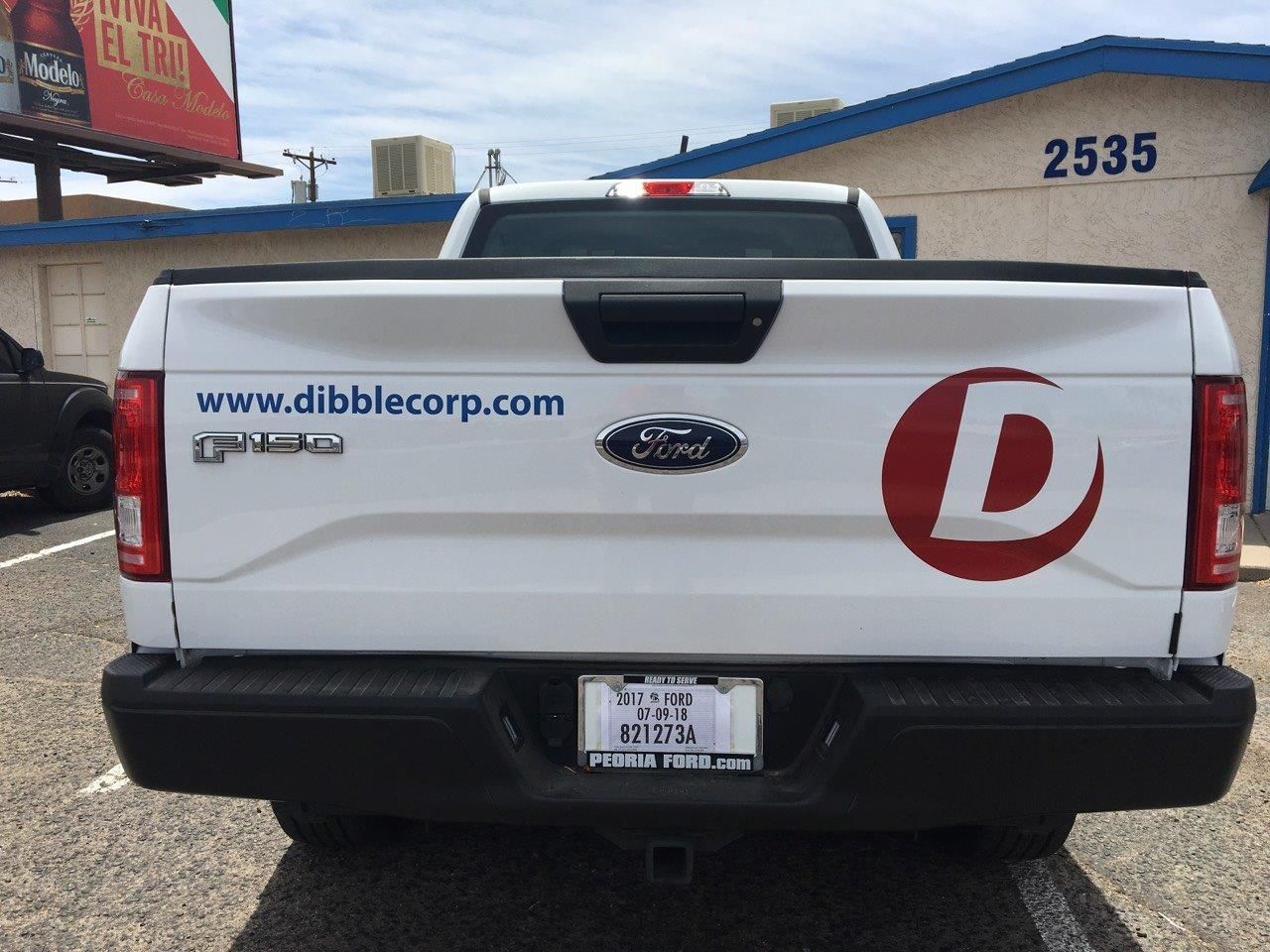 A white ford truck is parked in a parking lot