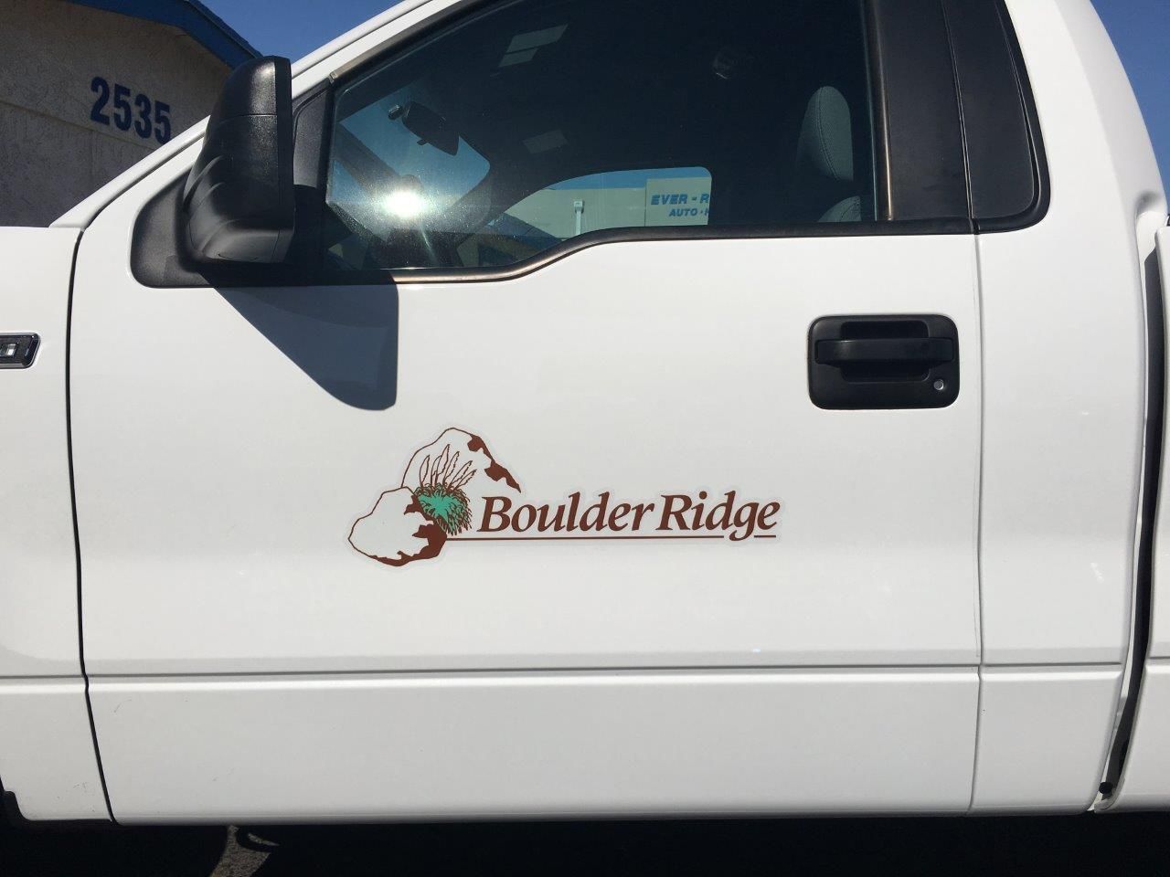 A white truck with the word boulder ridge on the door
