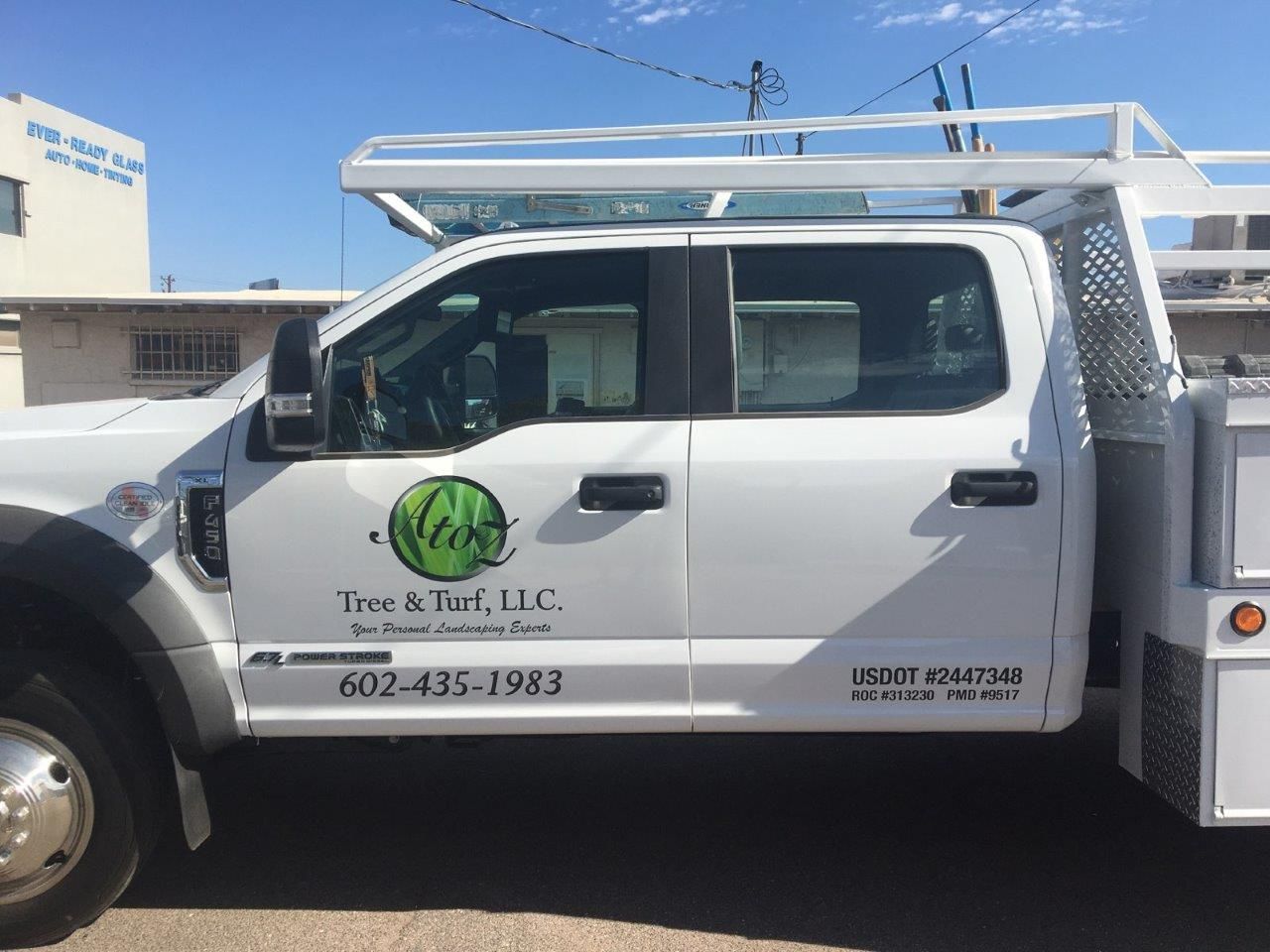 A white truck is parked in front of a building