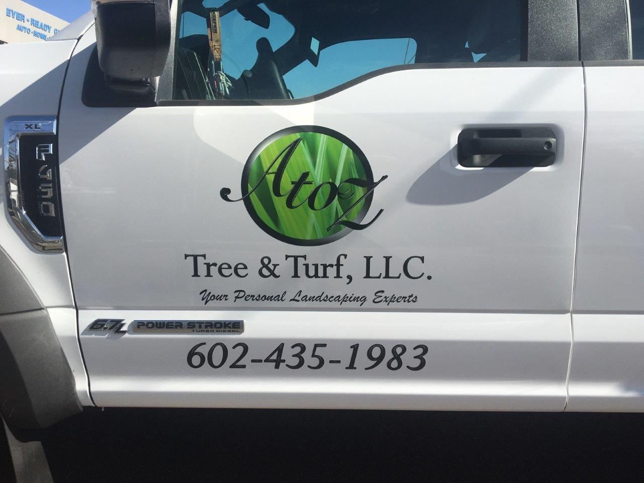 A white truck with a logo for tree & turf llc