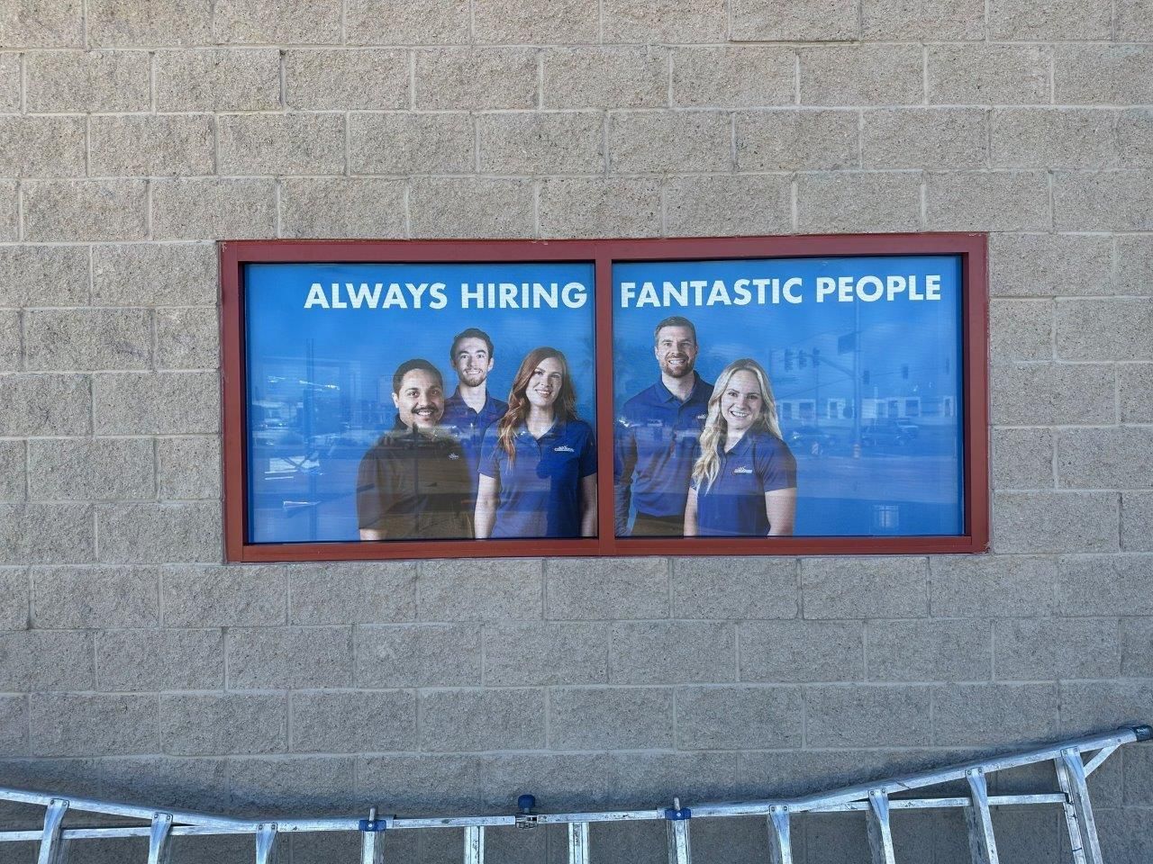 A sign on a brick wall that says always hiring fantastic people