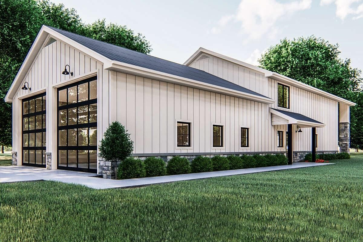 Modern beige metal building with large glass garage doors, windows, and grassy landscaping