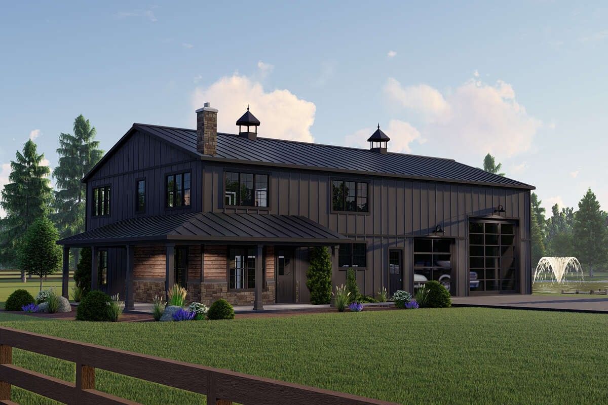 Modern black barn-style house with large windows, set on a green lawn under a partly cloudy sky