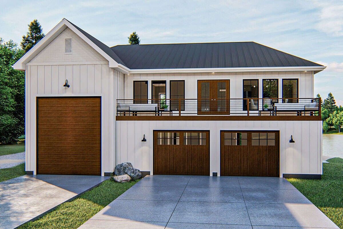 Two-story house with a large garage, white siding, dark roof, and a second-story balcony.
