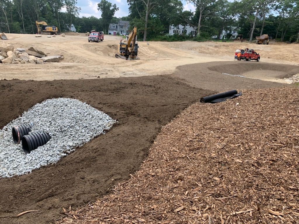 A construction excavation site with a lot of dirt and gravel.