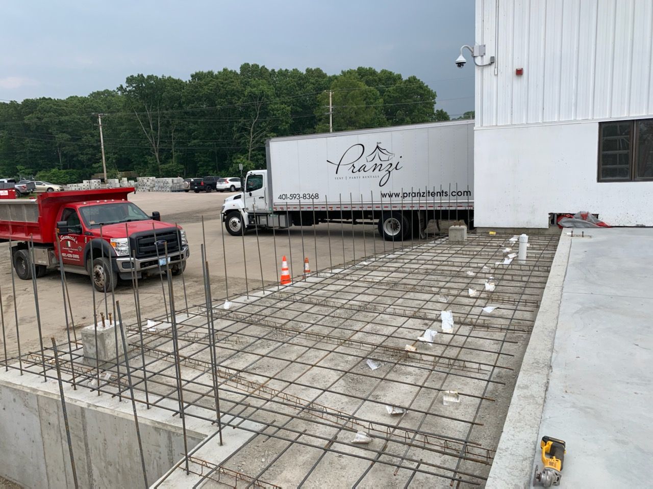 A dump truck is parked in front of a building under construction.