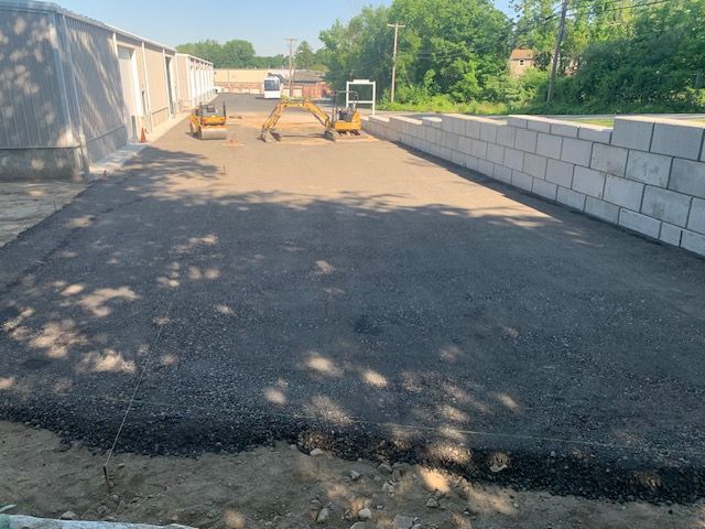 A brick wall is being built on the side of a road.