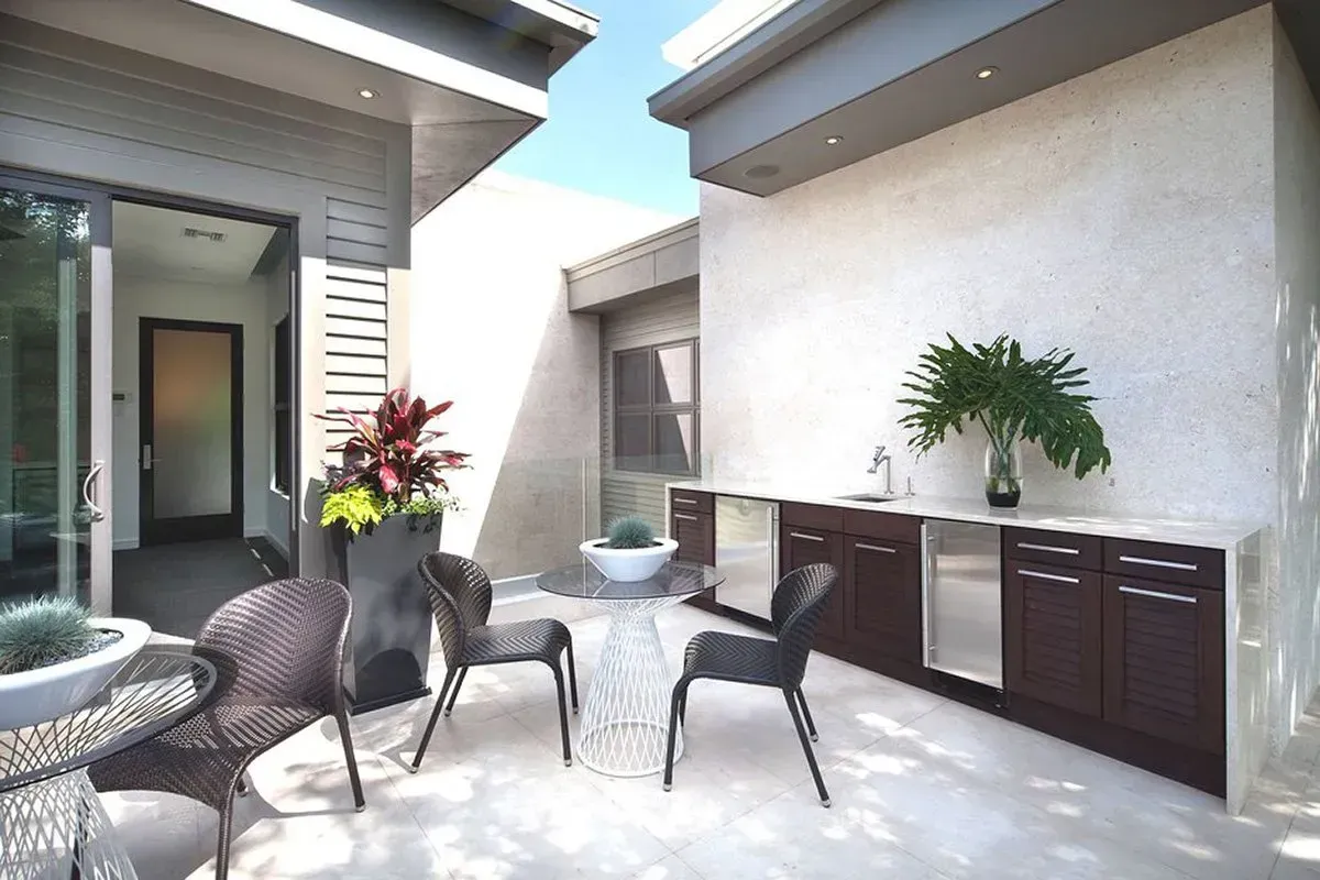 Outdoor patio with seating, built-in cabinetry, and sliding glass door.