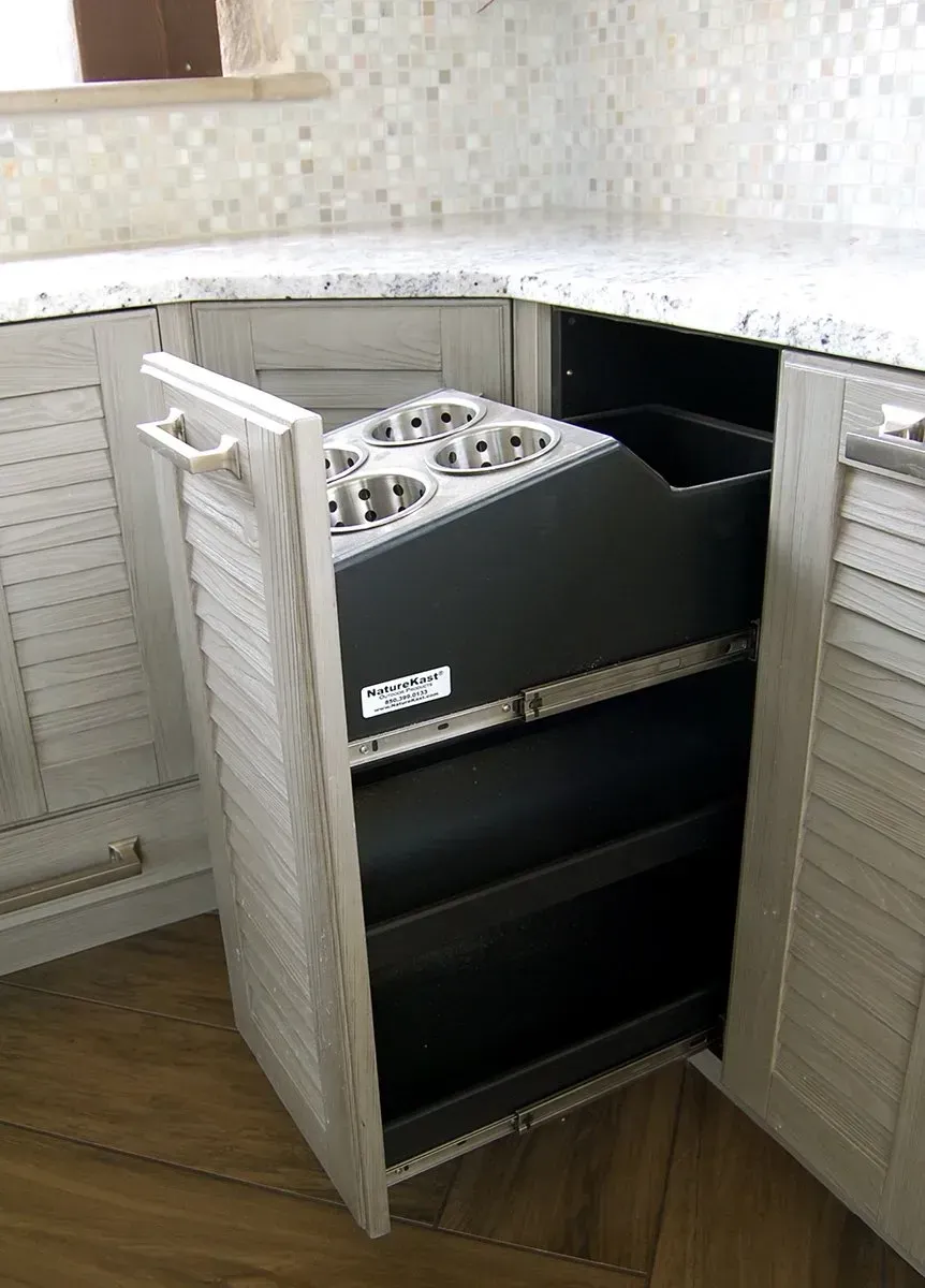 Pull-out cabinet with built-in cup holder and storage in a kitchen corner. The cabinet is open.