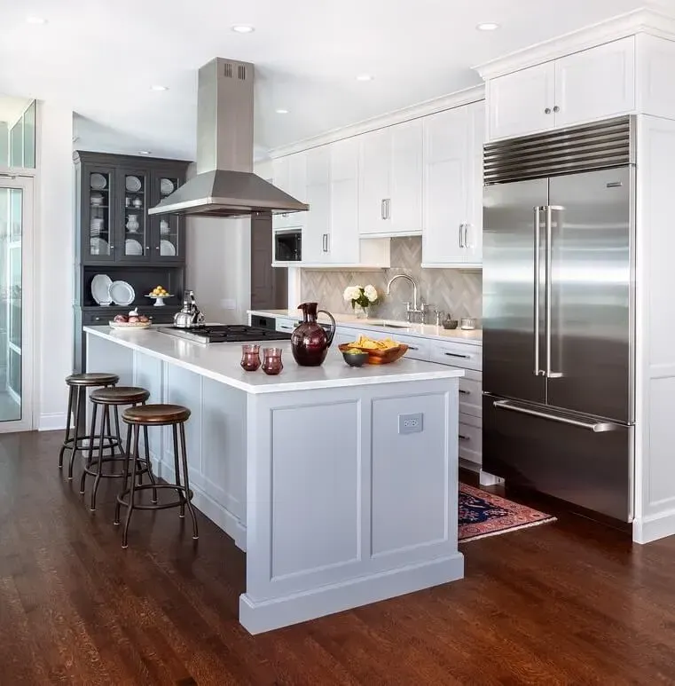 Modern kitchen with island, stainless steel appliances, white and gray cabinetry, dark wood floor.
