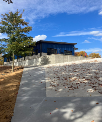 Modern building with blue glass on a concrete slope under a bright blue sky.