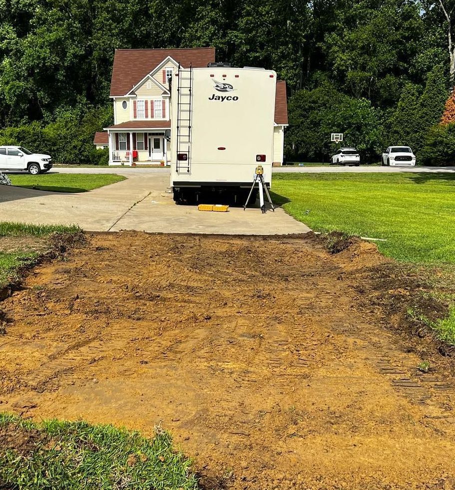 A trailer is parked in a driveway next to a house.