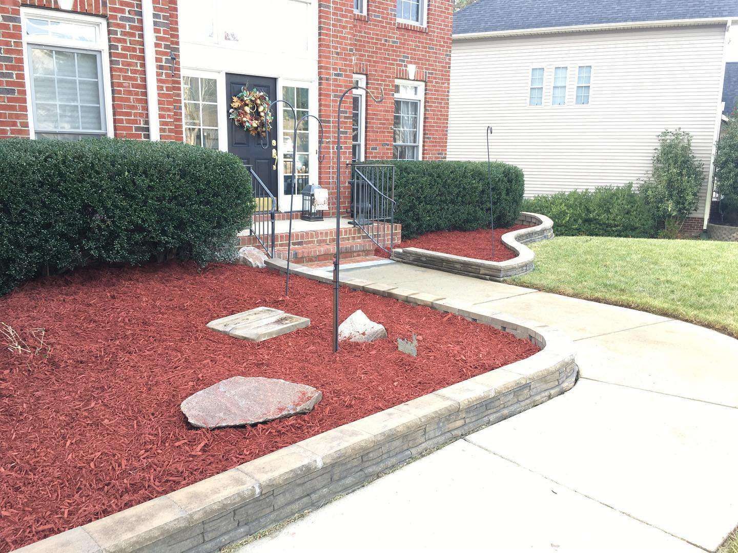A brick house with a walkway leading to the front door.