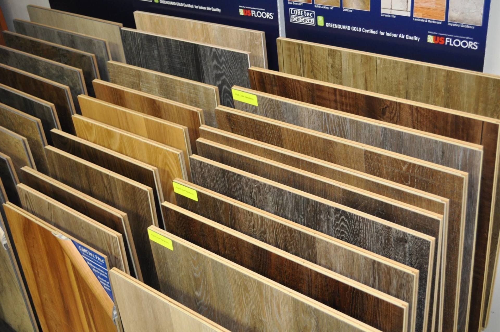 Flooring samples displayed in a retail setting, showcasing various wood-look laminate options.