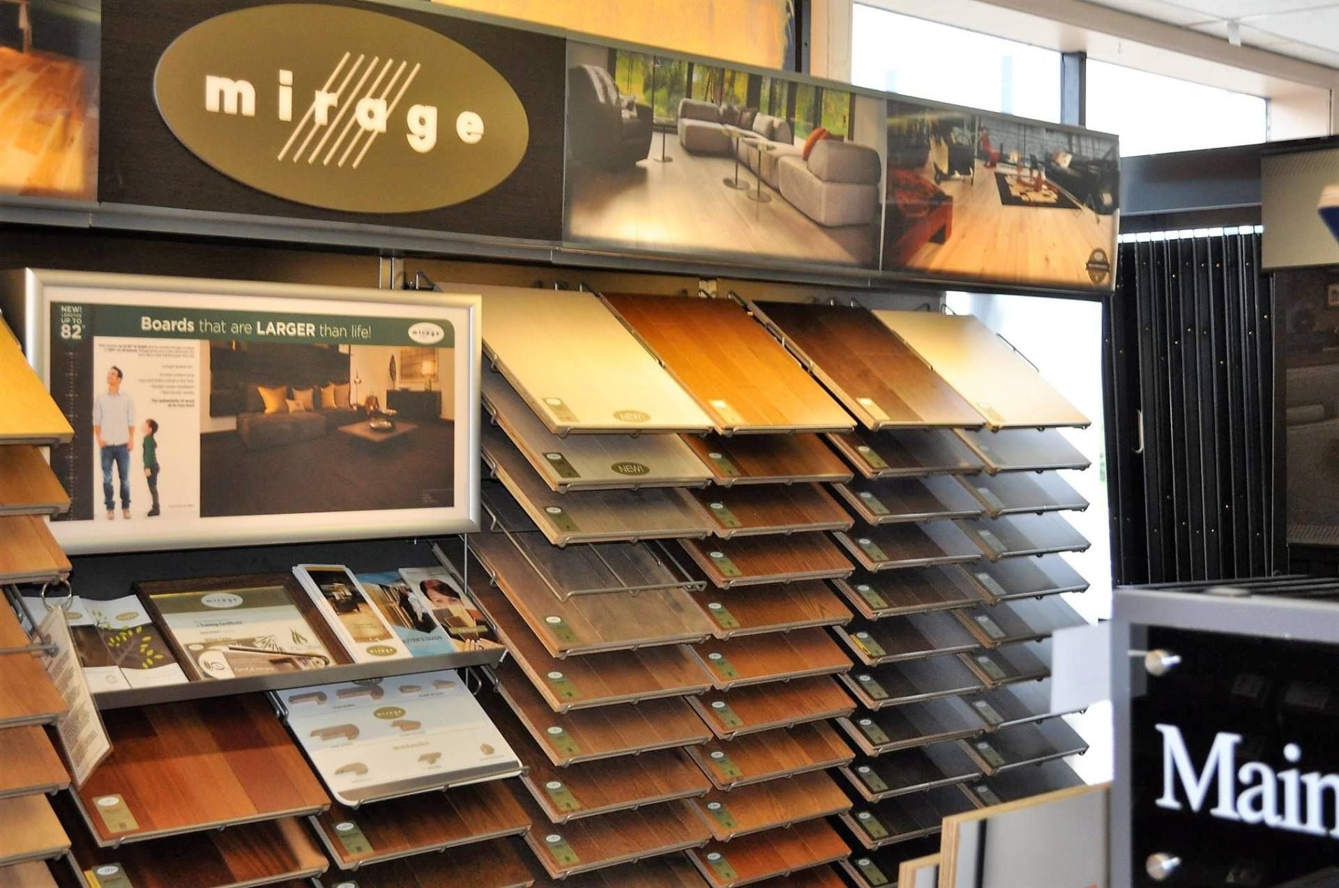 Display of various hardwood floor samples in a showroom, showcasing different wood tones and finishes.