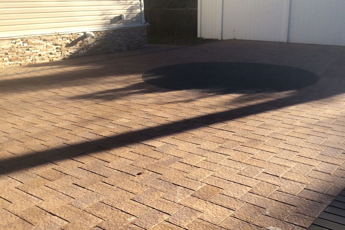 Backyard paver patio with freshly sealed pavers and green plants