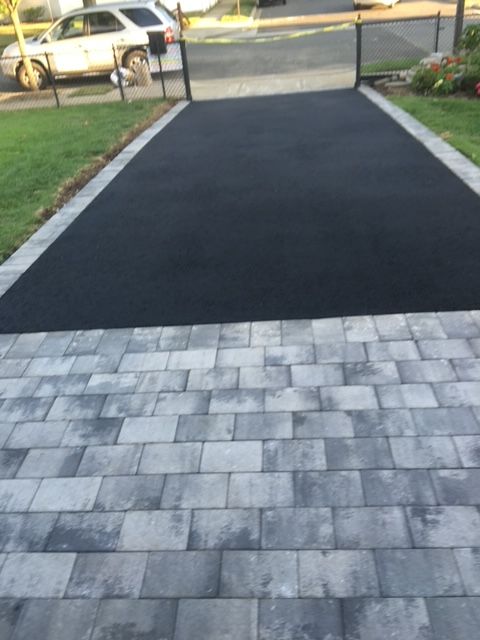 A car is parked on the side of the road in a driveway