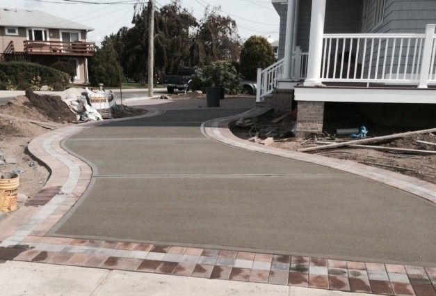 A concrete driveway is being built in front of a house