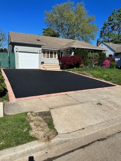 A house with a black driveway in front of it