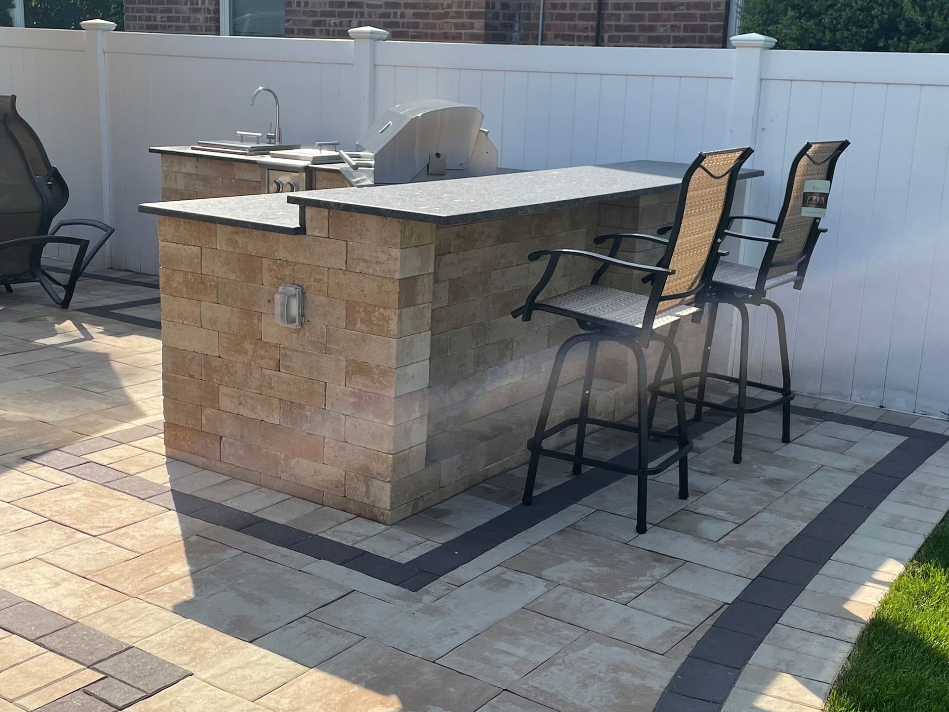 A beautifully designed paver walkway surrounded by greenery, leading to a cozy outdoor area.