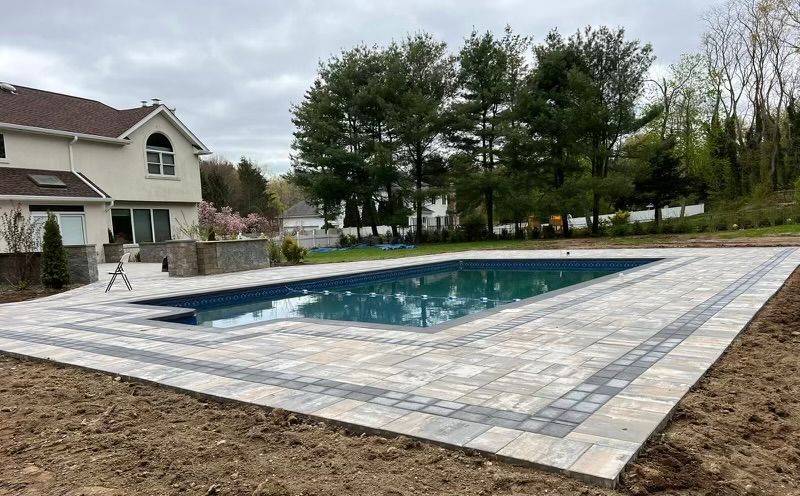 There is a large swimming pool in the backyard of a house.