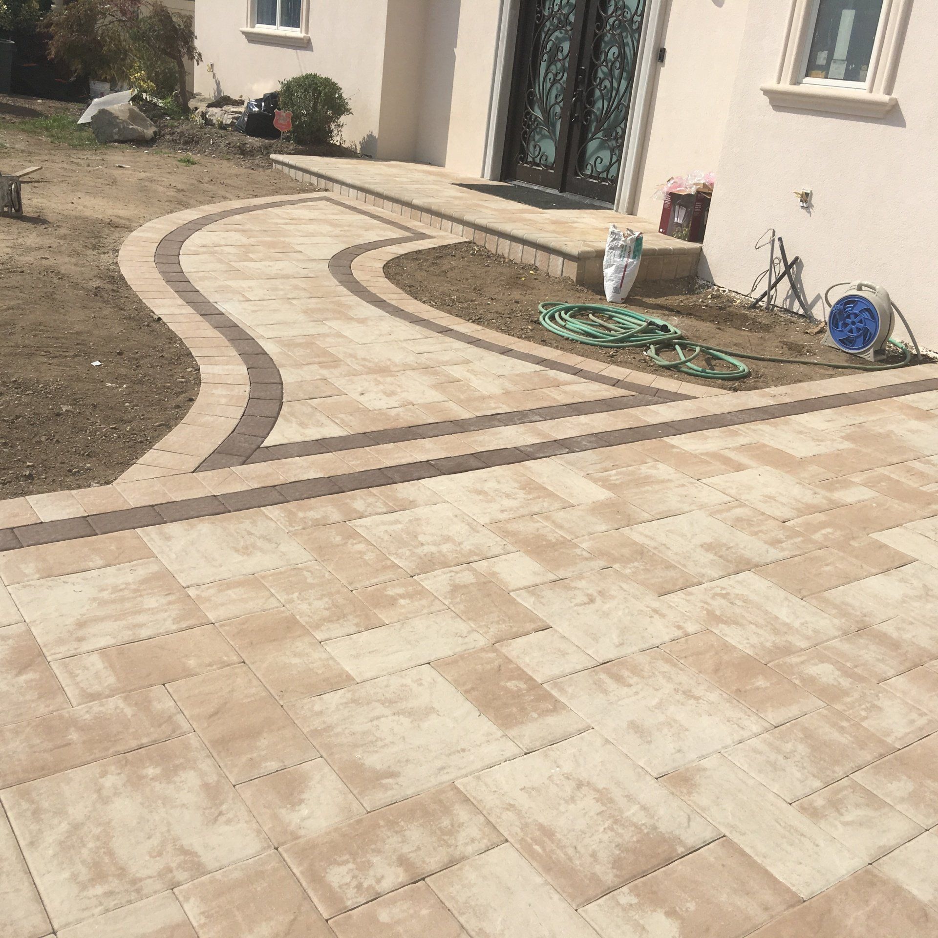 A brick walkway and pavers on a patio