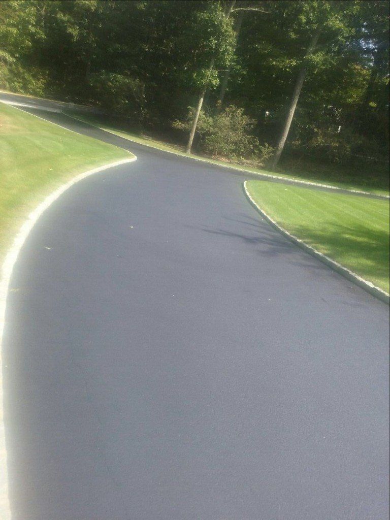 A curved driveway leading to a paved road