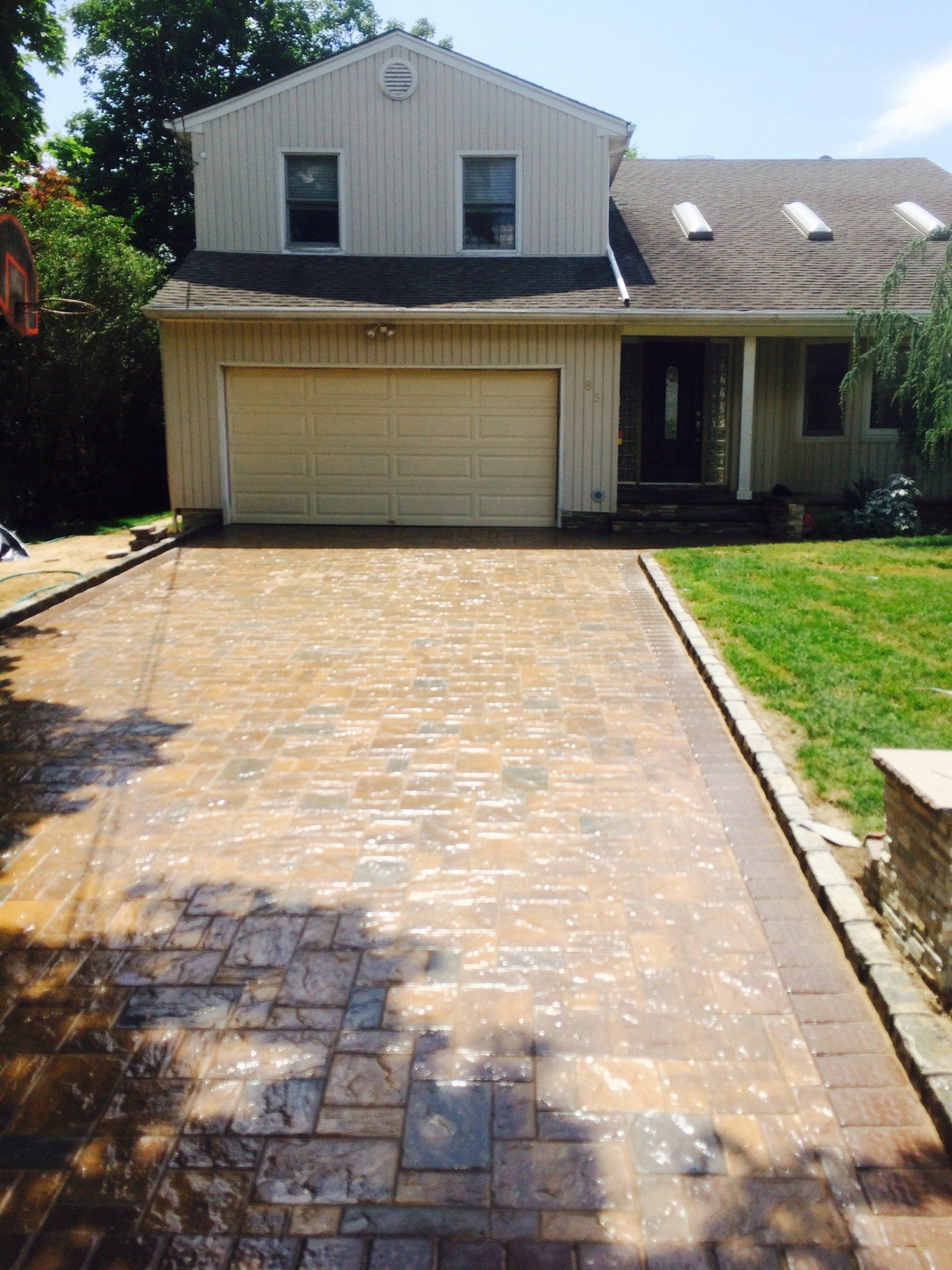 a driveway with a house and grass