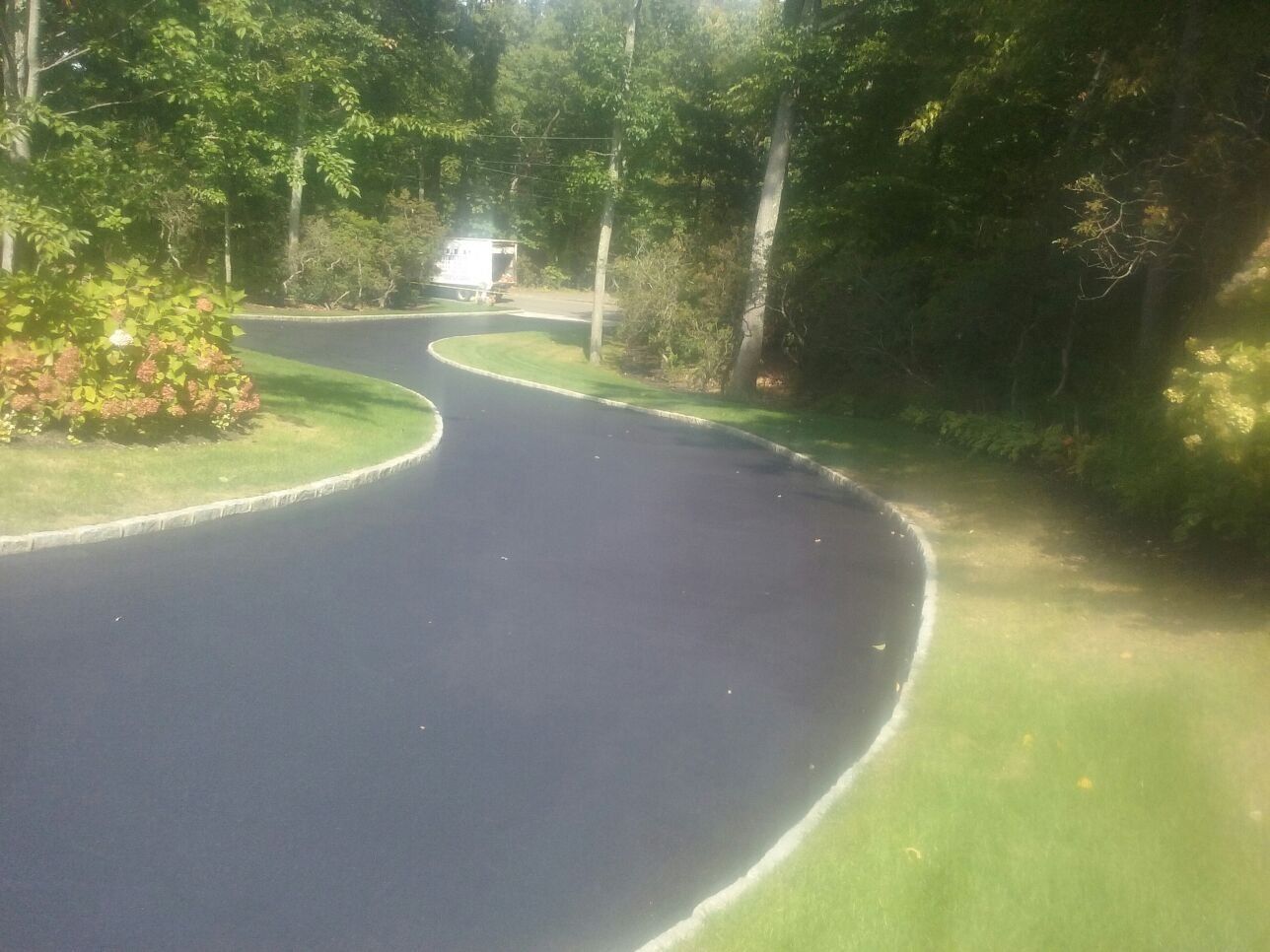 a road with grass and trees