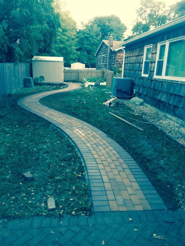 a brick walkway in a backyard