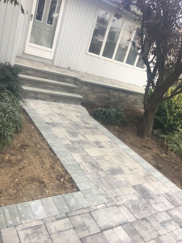 a stone walkway next to a house