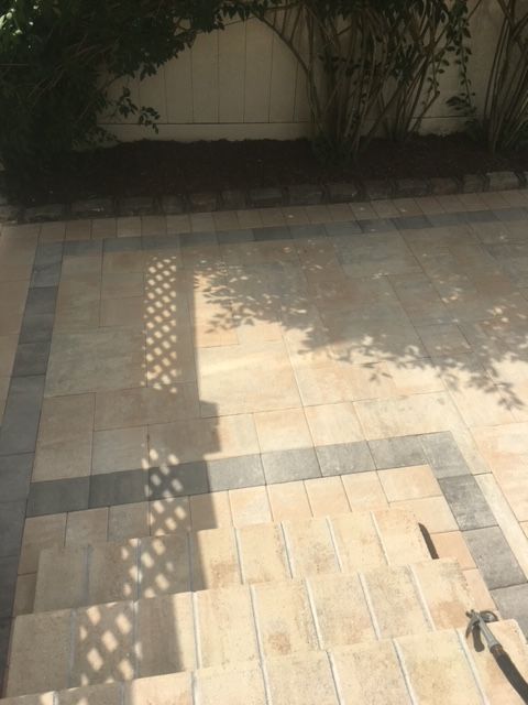 A brick patio with a shadow of a tree on it