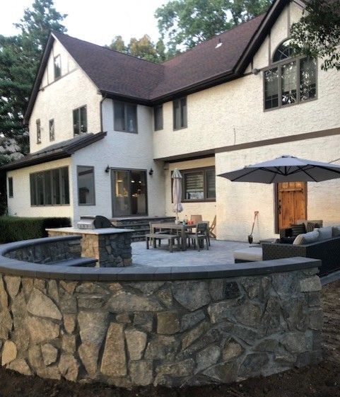 A large white house with a stone wall surrounding it