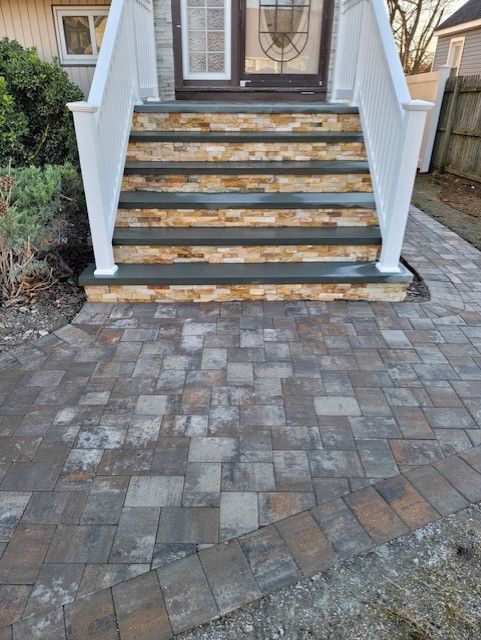 A brick walkway with stairs leading up to a house.