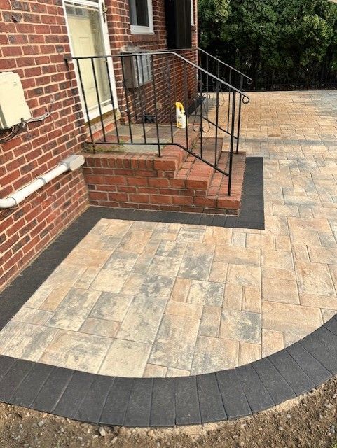A brick house with a patio and stairs in front of it.
