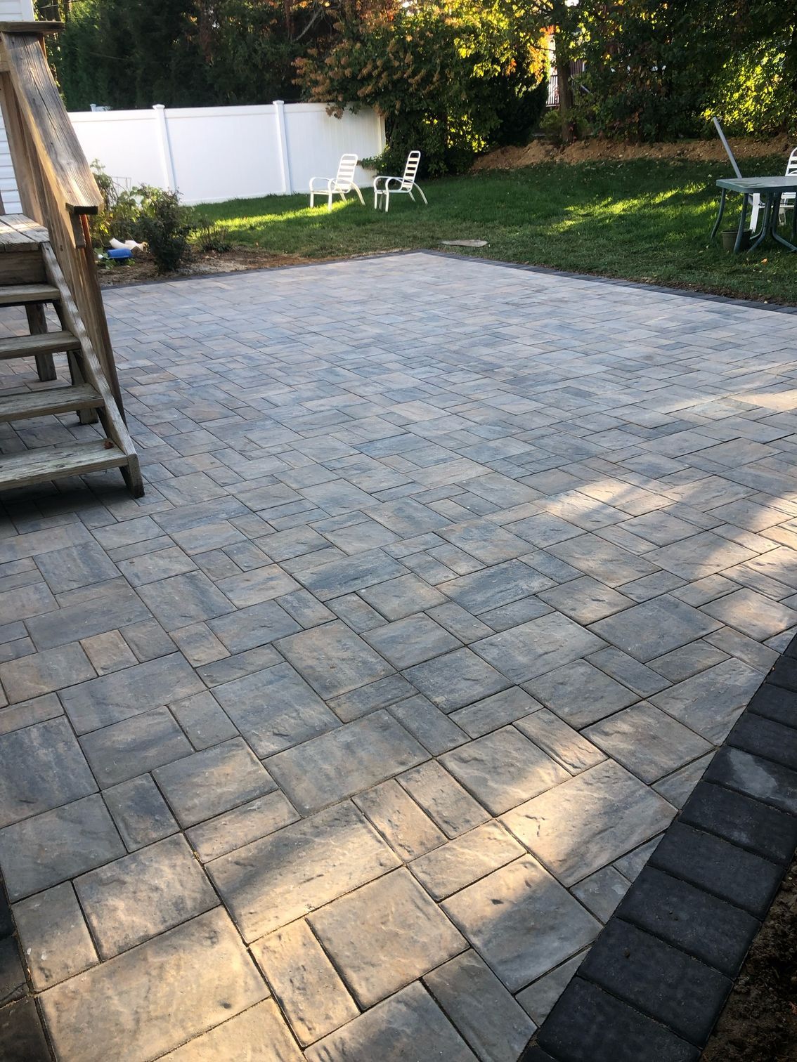 A patio with brick pavers and a stone walkway
