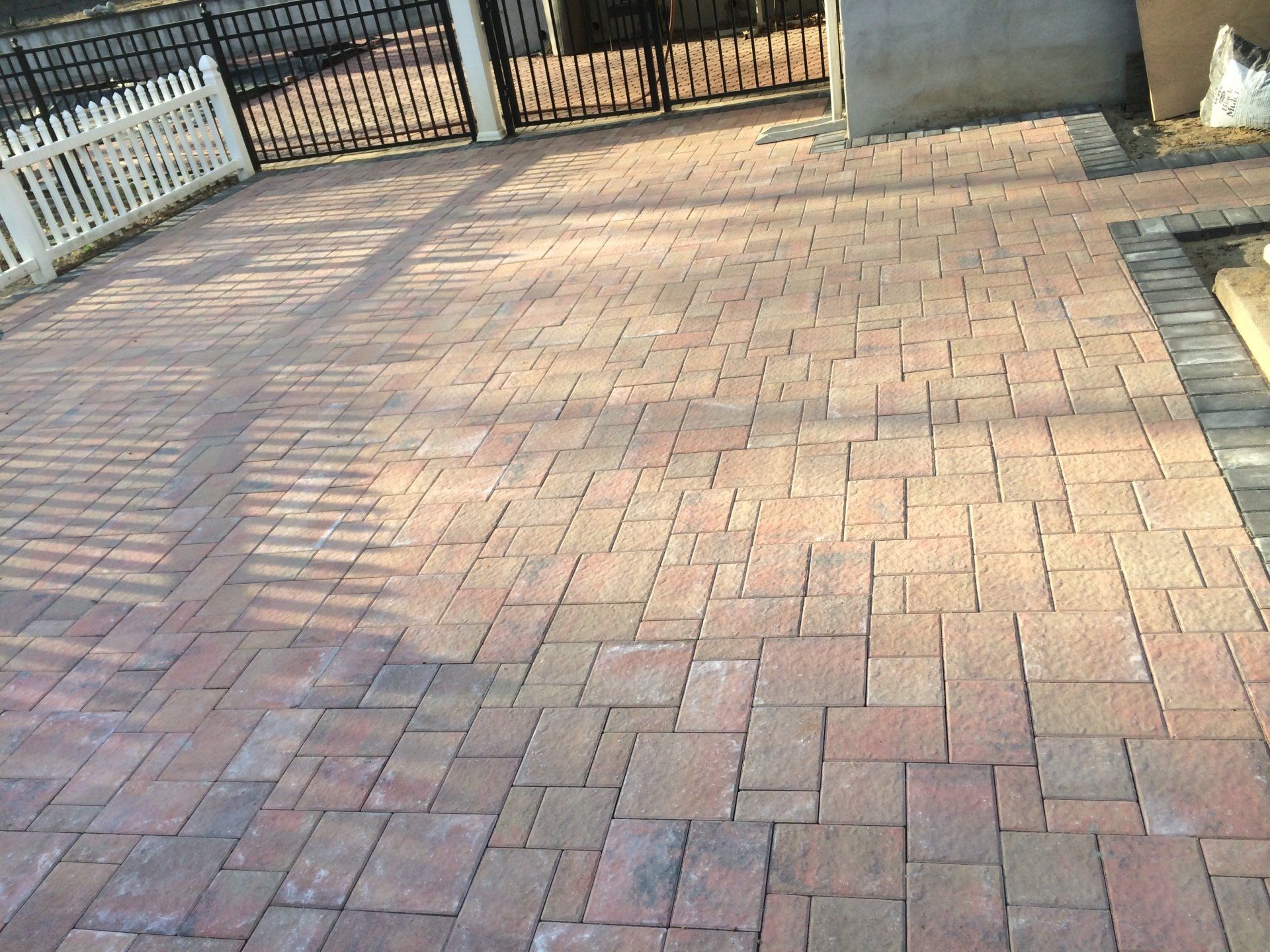 a brick patio with a fence and a gate