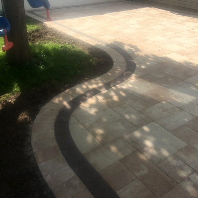 A curved white driveway with black border