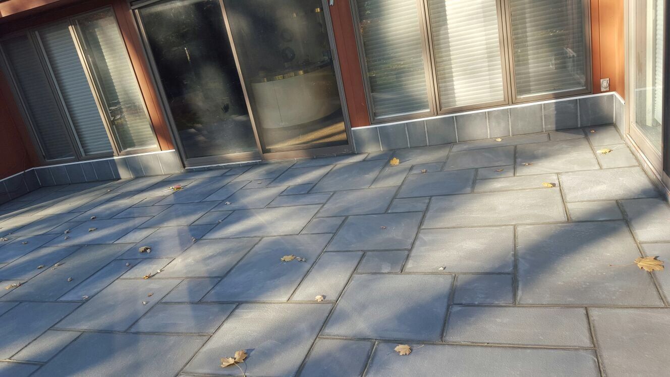 A paved walkway made of bricks with a visible shadow