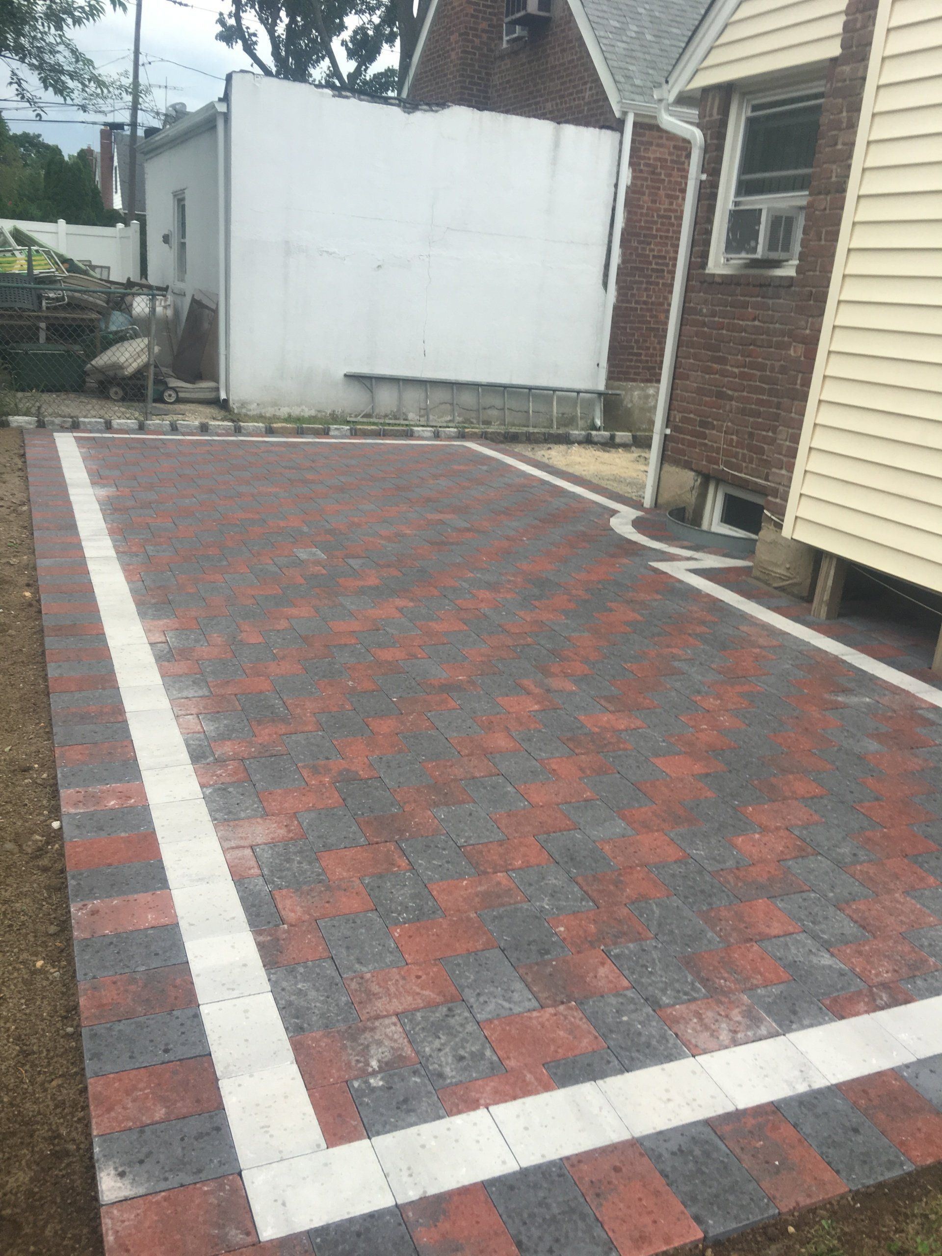 a brick driveway with a house in the background