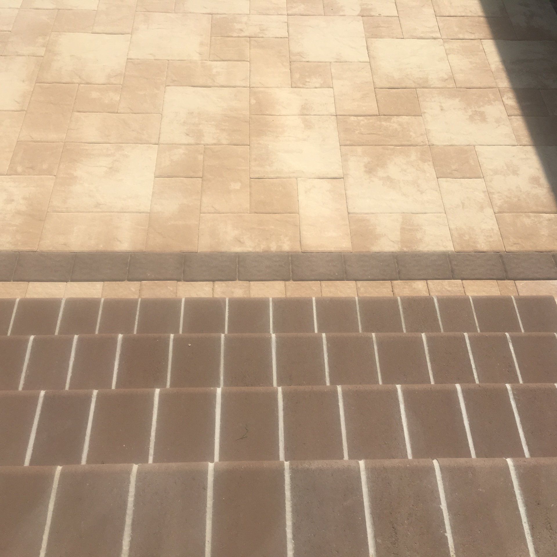 a stone stairs with a shadow on the ground