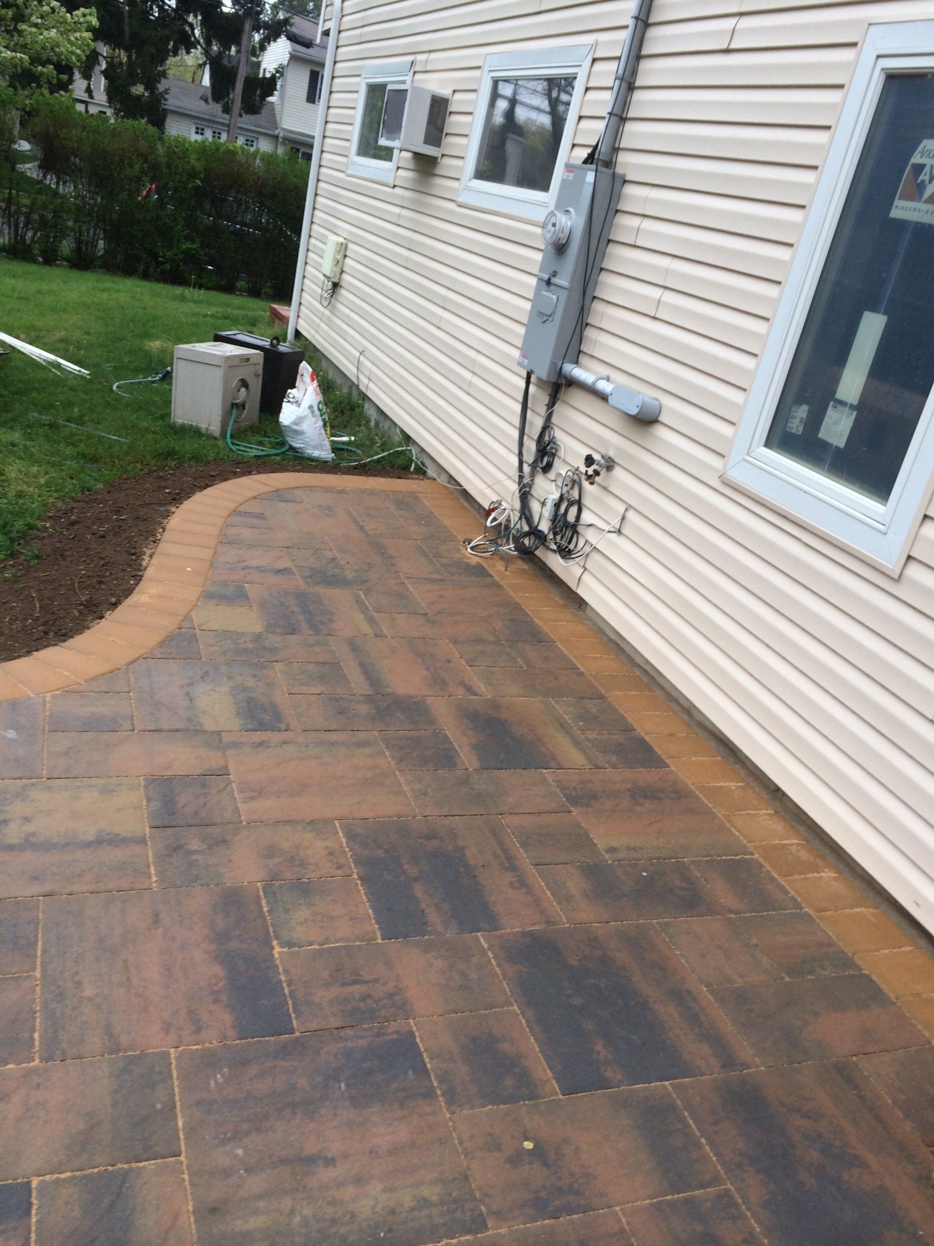 a brick patio with a white house