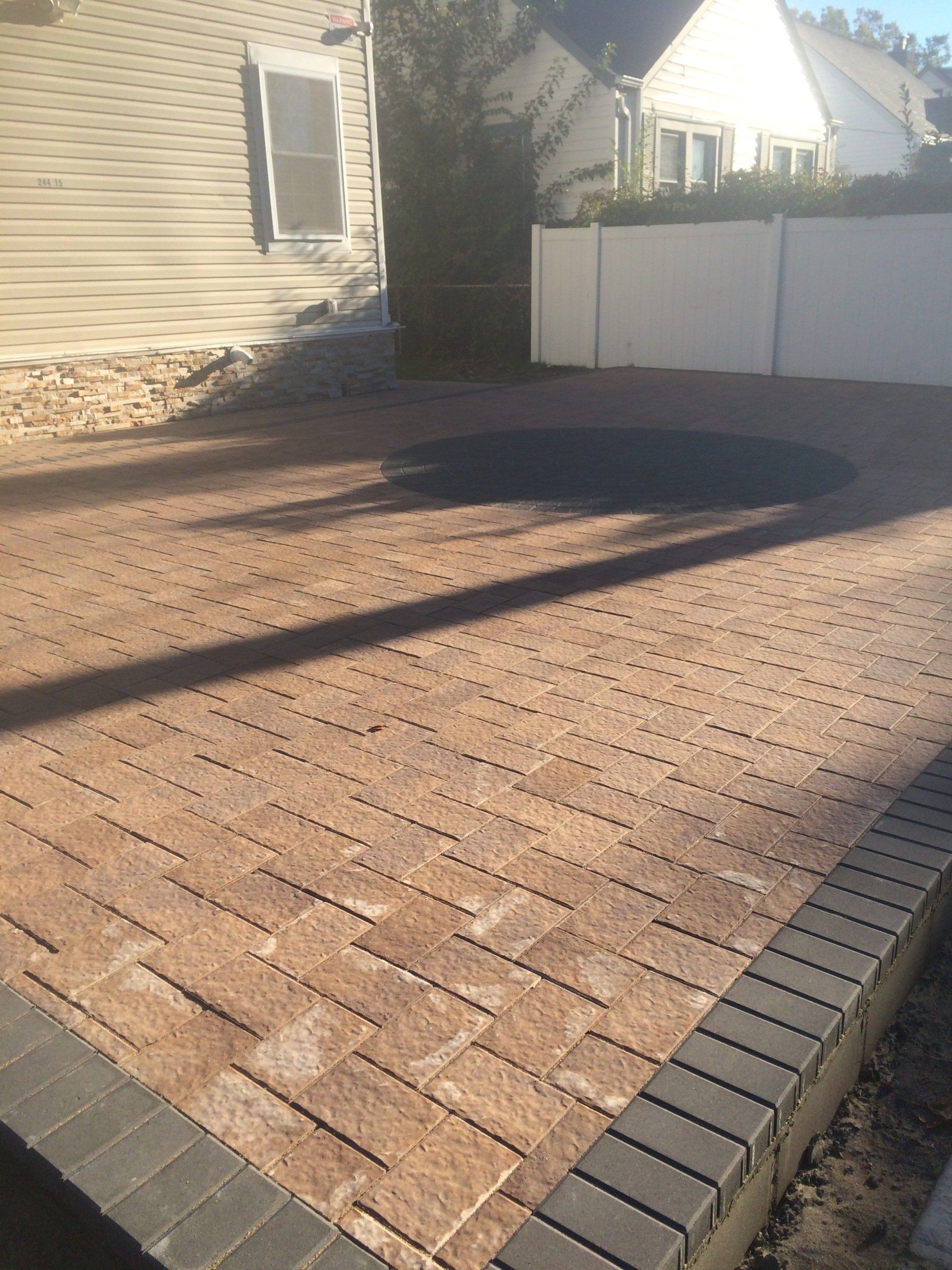 a brick patio with a circular object in the middle