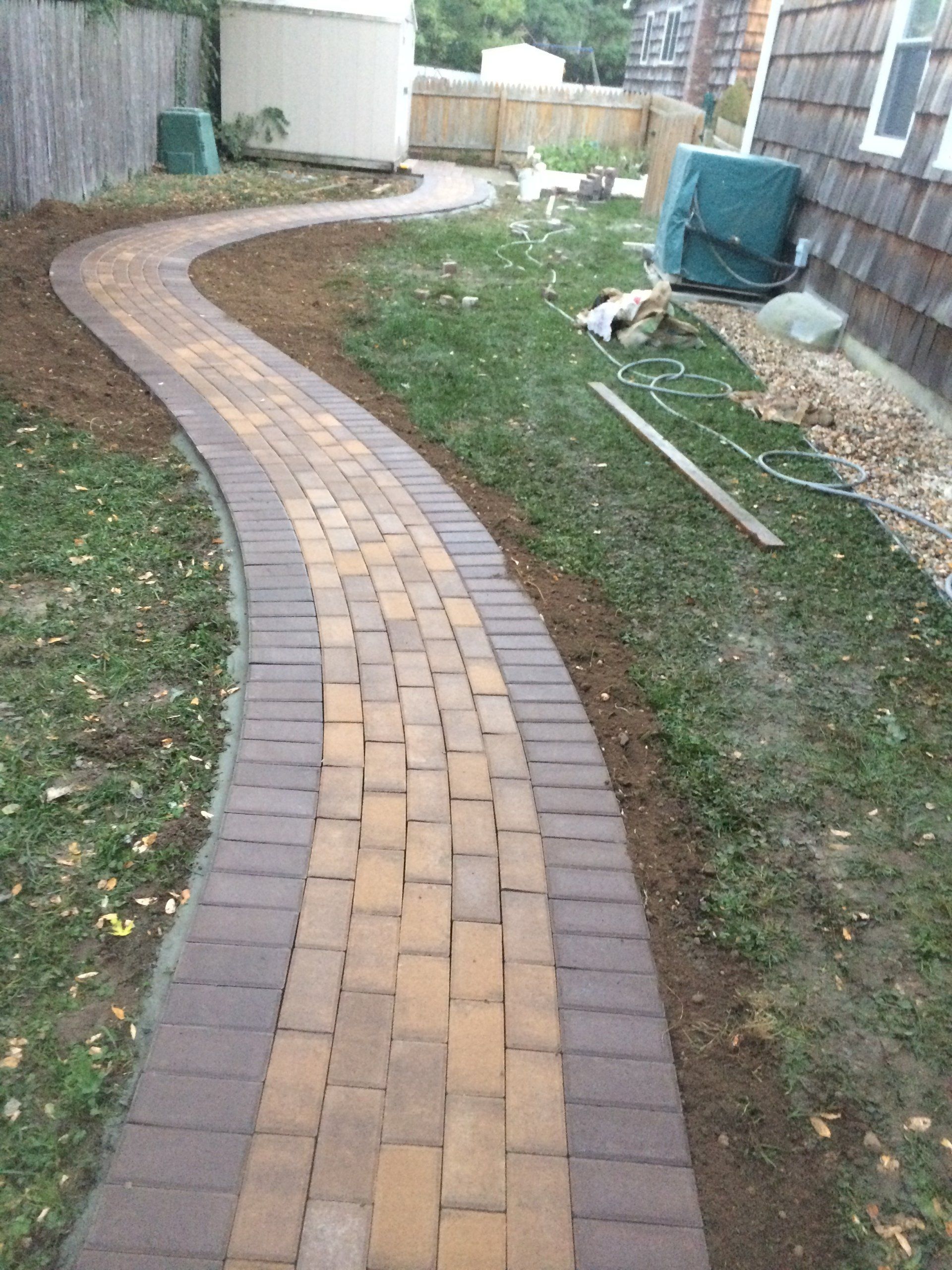 a brick walkway in a yard