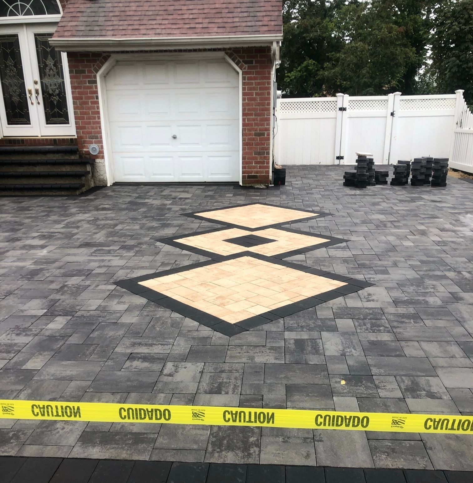 a brick driveway with a yellow tape