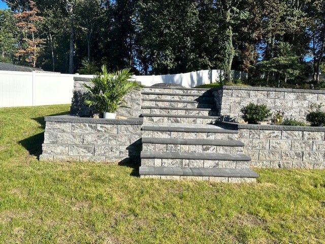 A set of stairs leading up to a brick wall in a yard.