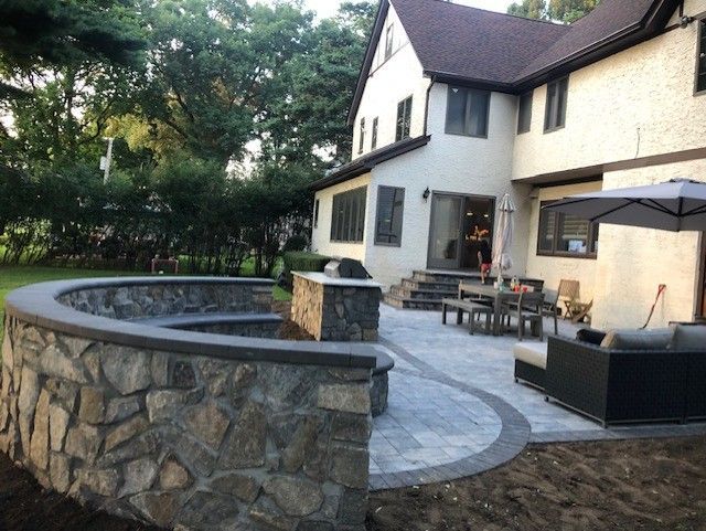 A house with a patio and a fire pit in front of it.