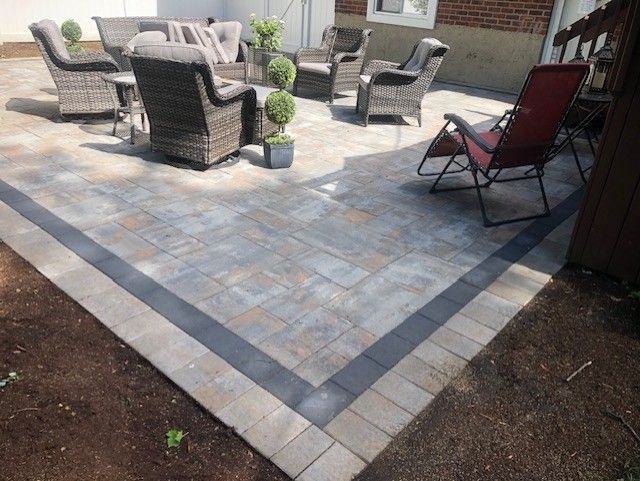A patio with a couch , chairs , tables and potted plants.