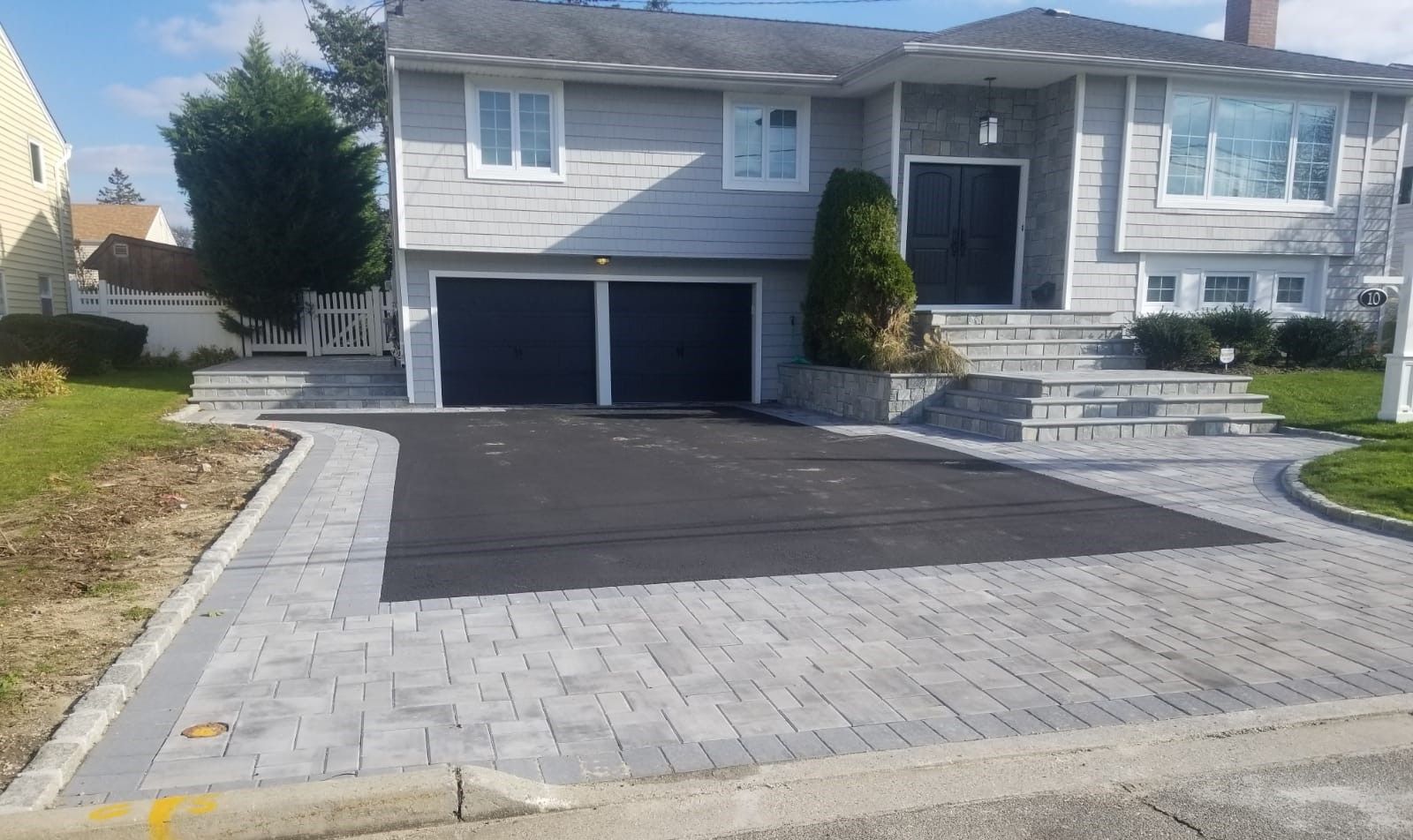 A house with two garage doors and a driveway in front of it.