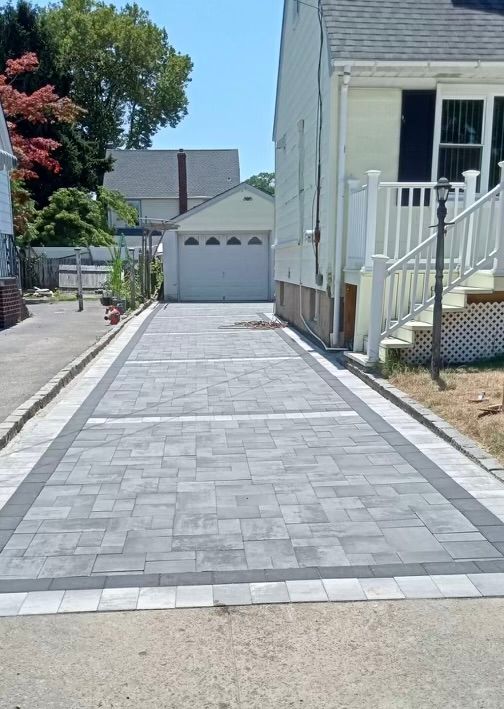A driveway leading to a house with a garage and stairs.